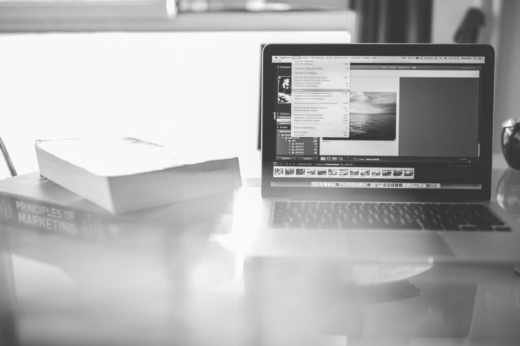 Creative digital marketing workspace with laptop, marketing book, and digital editing setup on office desk
